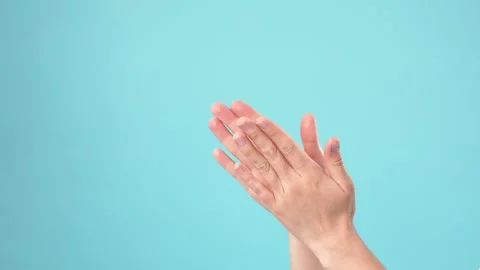 Close-Up of Hands Clapping Against Blue Background Stock Footage 346229310