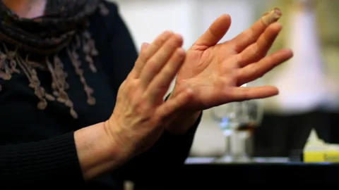 Close-up of hands clapping in rhythmic motion, wrapped in a warm red and Stock Footage 304146754