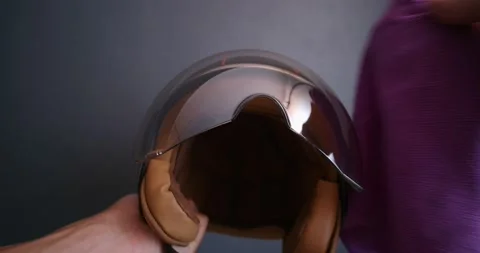 Close-up. Hands cleaning helmet visor with microfiber cloth. Stock Footage 172422479