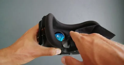 Close-up. Hands cleaning lens in virtual reality helmet with microfiber cloth. Stock Footage 172422514