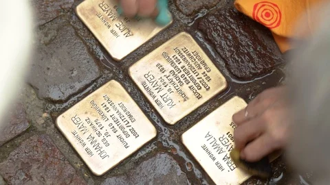 Close Up of Hands Cleaning Memorial Plaques on Ground with Sponges Video stock 122333927