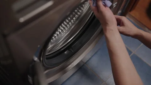 Close-up of hands cleaning rubber seal of washing machine door with microfiber Stock Footage 313300282