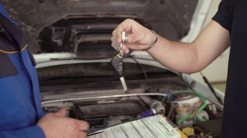 Close up of hands client of repair car service is giving keys to car mechanic Video stock 74605933
