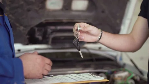 Close up of hands client of repair car service is giving keys to car mechanic Video stock 74606765
