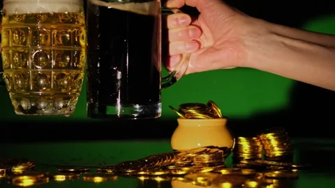 Close-up of hands clinking with beer mugs on a green background. Stock Footage 264493760