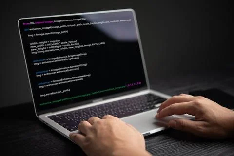 Close-up of hands coding on laptop, displaying programming interface. Repre.. Stock Photos