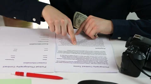 Close-up of hands completing a photography service payment - meticulously Stock Footage 314707465