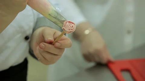 Close up of hands of confectioner doing cream rose flower for cake decorating. Stock Footage 50476271