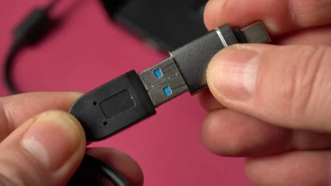 Close-up of hands connecting USB cable to adapter, showcasing the progression of Stock Footage 329430842