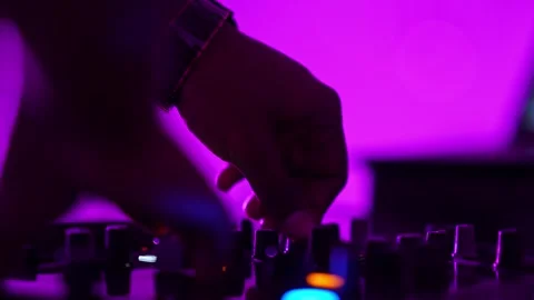 Close-up of hands controlling DJ mixer faders during a vibrant club party c.. Video stock 331790340