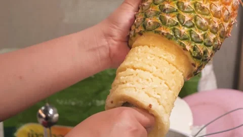 Close-Up of Hands Coring and Peeling a Fresh Pineapple Stock Footage 345649049