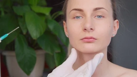 Close-up of hands of cosmetologist making botox injection to female lips. Young Stock Footage 73877241