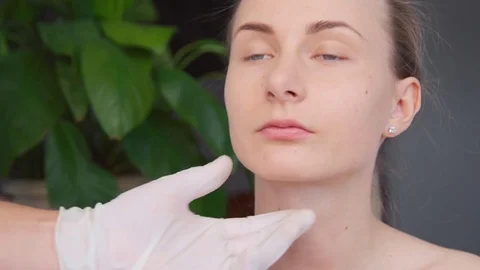 Close-up of hands of cosmetologist making botox injection to female lips. Young Stock Footage 73877279