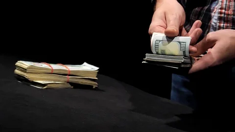 Close-up hands count out a pack of dollars and put them in a pile in slow motion Stock Footage 129786474