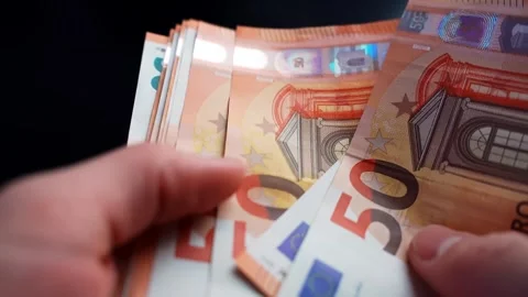 Close-up of hands counting 50 euro banknotes on a dark table, shallow depth of Vídeo Stock 328586499