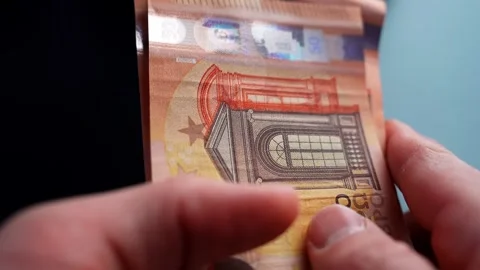 Close-up of hands counting 50 euro bills on a dark table with shallow depth of Video stock 328874017