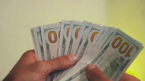 Close up of hands counting and holding a stack of hundred dollar bills Stock Footage 346074580