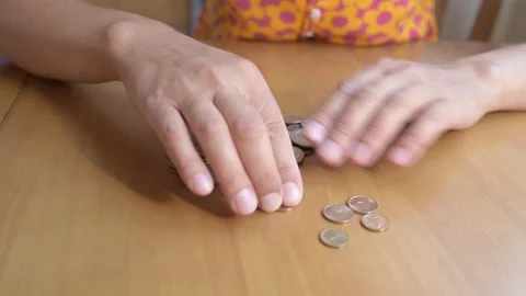 Close-up of hands counting Bulgarian Lev coins on a wooden table. Concept of Stock Footage 316120162