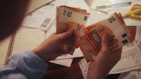 Close up of hands counting euros while sitting at a table. Utility bills and Stock Footage 324031772