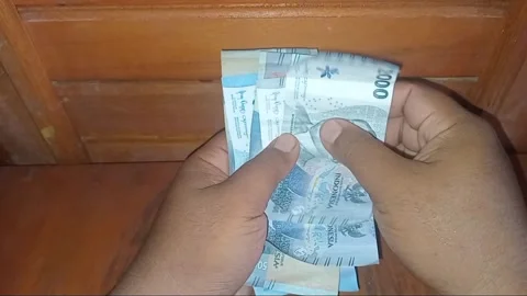 Close Up of Hands Counting Indonesian Rupiah Banknotes 50000 and 2000 Stock Footage 328273929