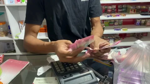 Close Up of Hands Counting Indonesian Rupiah Cash at Small Store Counter 库存影片 335646908