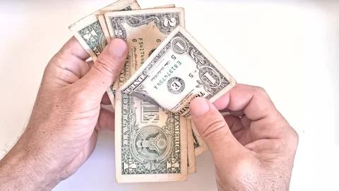 Close up of hands counting several United States dollar bills carefully Stock Photos