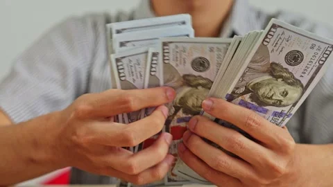 Close up of hands counting thick stacks of United States one hundred dollar Stock Footage 338416901