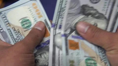 Close up of hands counting a wad of 100 US dollar bills Stock Footage 272500704