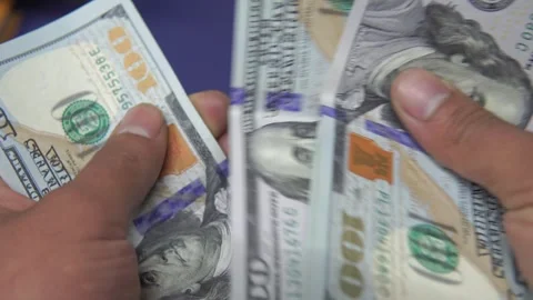 Close up of hands counting a wad of 100 US dollar bills Stock Footage 272501849