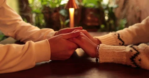 Close-up of the hands of a couple in love sitting at a table in a cafe Stock Footage 247001809