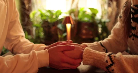 Close-up of the hands of a couple in love sitting at a table in a cafe Stock Footage 247001889