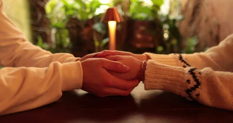 Close-up of the hands of a couple in love sitting at a table in a cafe Stock Footage 247001898