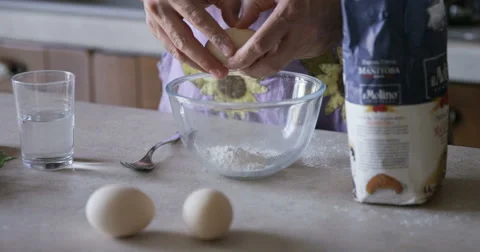Close up of hands cracking eggs into bowl Stock Footage 65875944