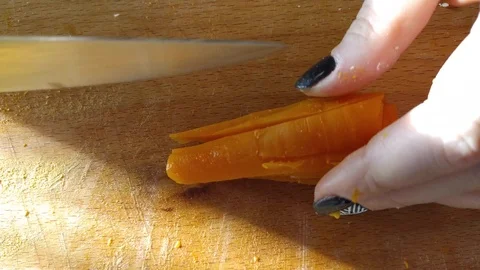 Close-up. hands cut carrot into salad cubes. cutting vegetables on a wooden boar Stock Footage 121003702