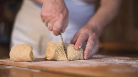 Close up hands cut shape in rolling-pin dough into pieces on wooden board Stock Footage 129240169