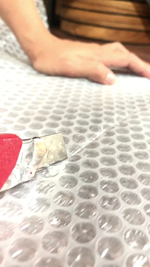 Close Up of Hands Cutting Bubble Wrap Plastic with cutter4K Stock-Footage 337720618