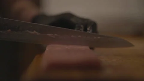Close-up of hands cutting meat with large knife Stockbeeldmateriaal 336374701
