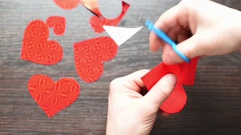 Close-up hands cutting out shapes of red hearts . Top view horizontal 4k Stock Footage 232023185