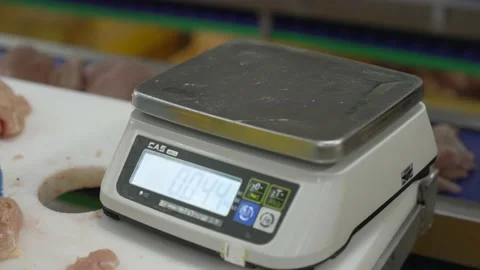 Close-up of hands cutting pieces of meat and weighing it on a scale. Stock Footage 228260576