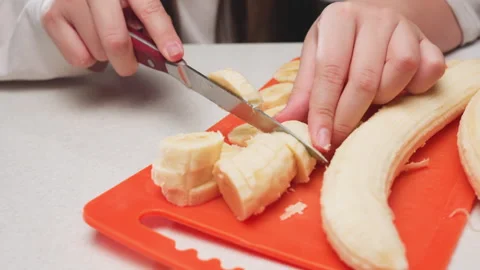 Close Up Hands Cutting Plantain Into Circular Slices On Board Stock Footage 319430456