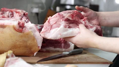 Close-up of hands cutting raw pork: trimming, bone separation, and portioning Stock Footage 343250046
