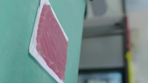 Close-up of hands cutting red fish. Sushi chef slicing fresh tuna for sushi. 4K Stock Footage 240250998