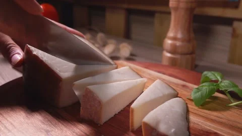 Close up of a hands cutting a semi hard sheep cheese into pieces Stock Footage 136455929