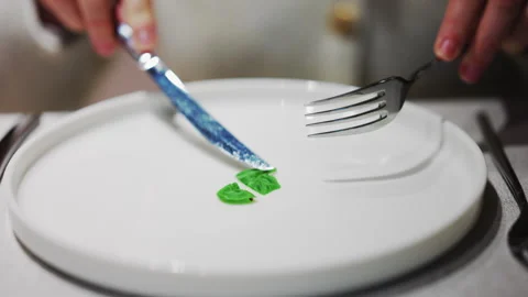 Close up of hands cutting a small green leaf garnish on a white plate Stock Footage 332568433