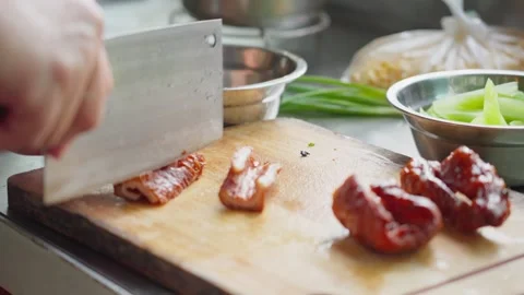 Close-up of hands cutting thin slices of braised sausage on a cutting board Stock Footage 341503991