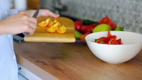 Close-up of hands cutting a tomato to prepare a salad of fresh vegetables Stock Footage 252049760