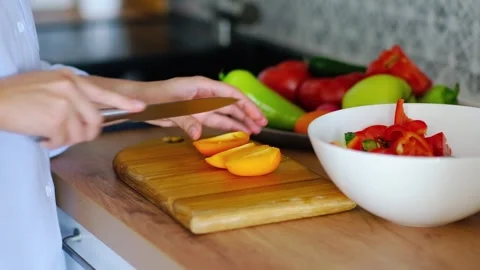 Close-up of hands cutting a tomato to prepare a salad of fresh vegetables Stock Footage 252637217