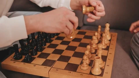 Close up hands of dad and a daughter are playing chess on a wooden board on a co Stock Footage 330779682