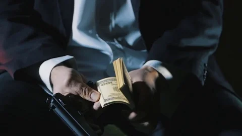 Close-up hands of a dangerous man with a gun counts the money. Dirty Money Mafia Stock Footage
