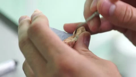 Close up hands dentist makes a denture tooth cleanliness doctor Video stock 137403641